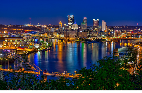 a long bridge over a body of water with a city in the background