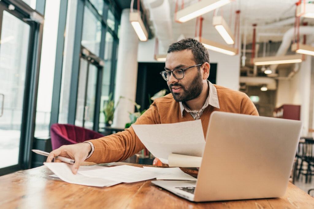 An employee works at a table in a shared office space.