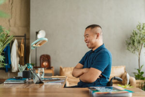 A man sitting at a desk with his arms crossed