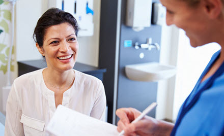 A doctor speaks with a patient and takes notes.