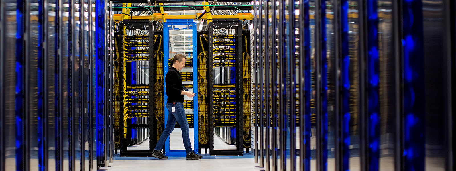 Image of a worker walking amidst servers.