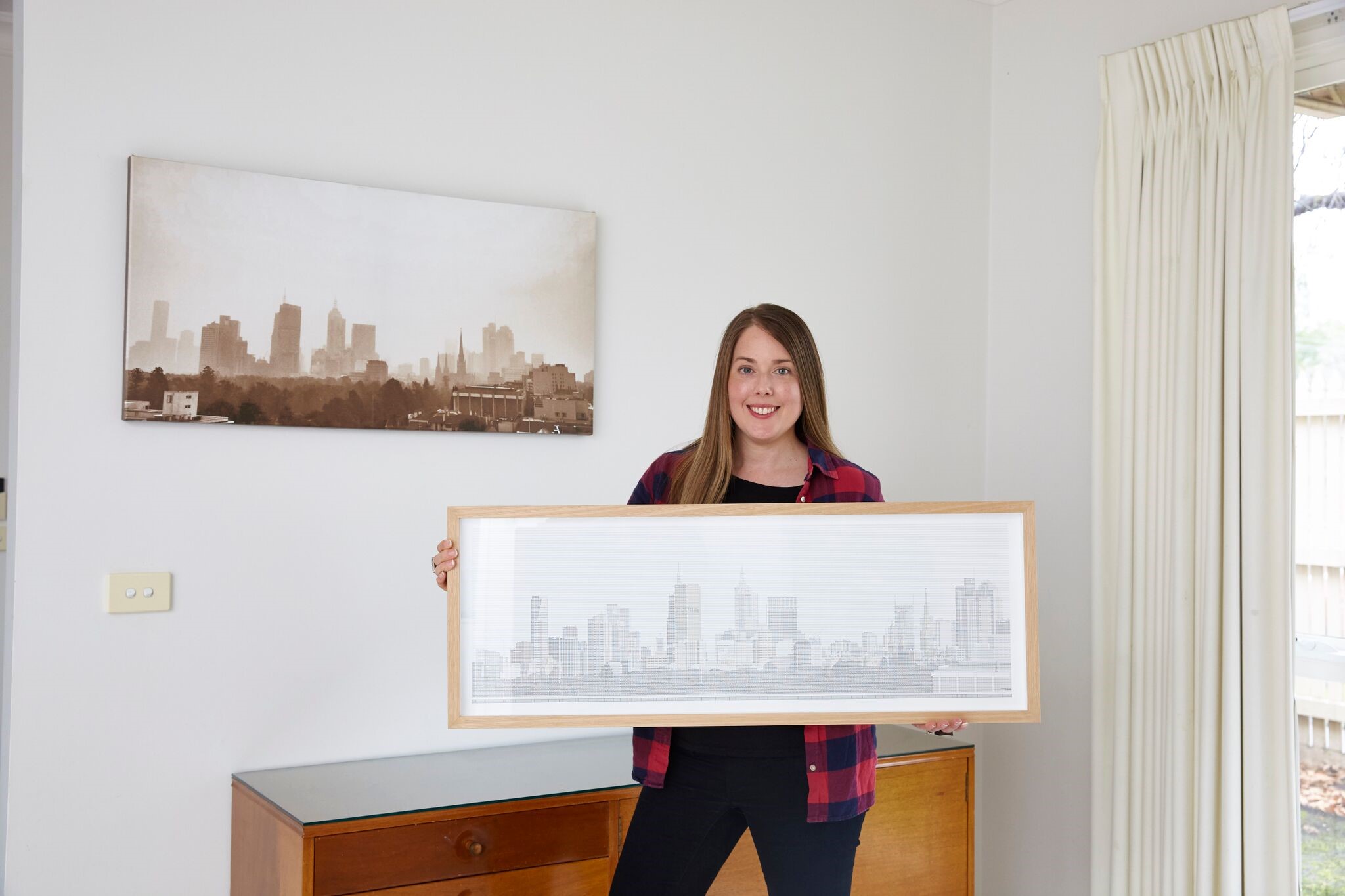Image of Emma Stevens holding up a Spreadsheet Skyline, made using Excel.