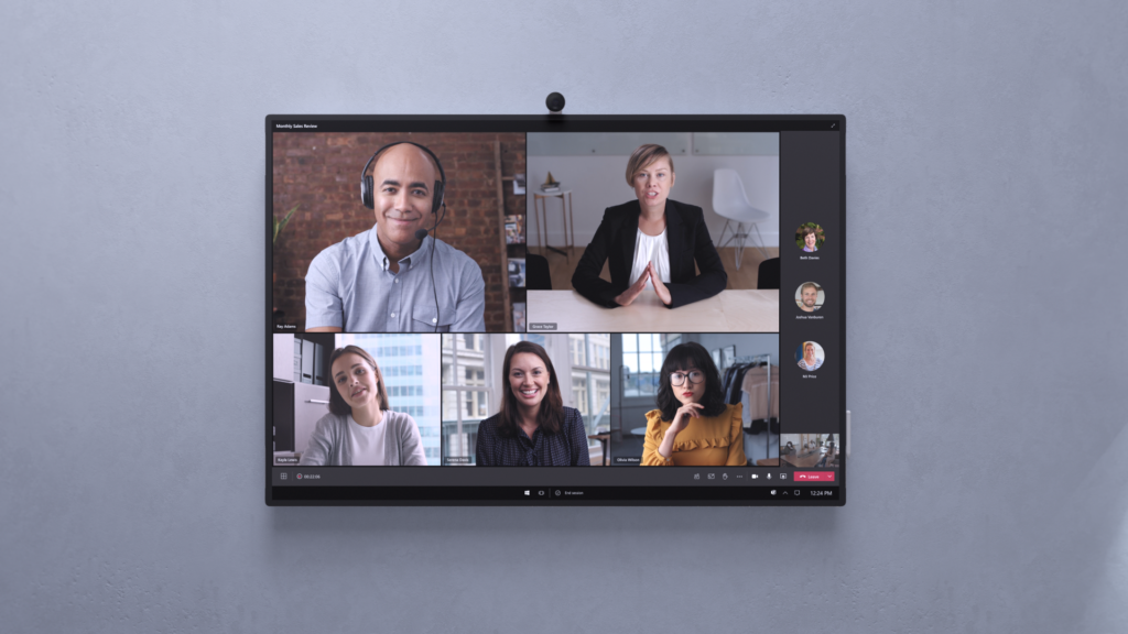 Five people using Teams Rooms, shown on a TV hanging on the wall.