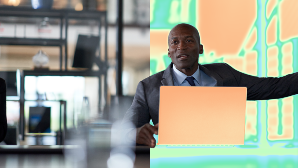 A man in a suit and tie sitting in front of a laptop