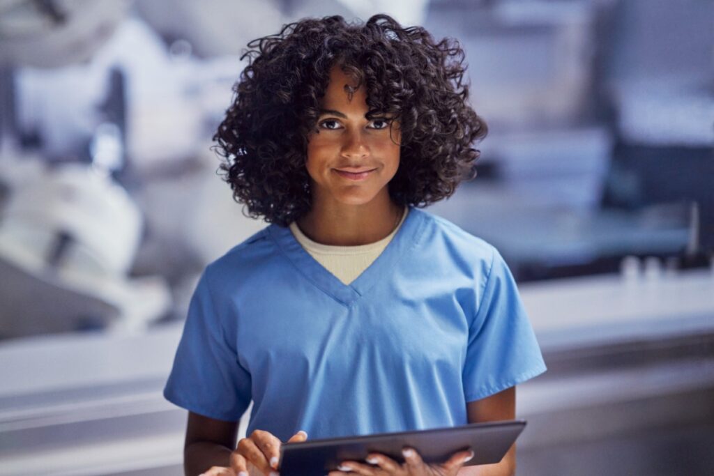 a healthcare worker in scrubs holding a tablet
