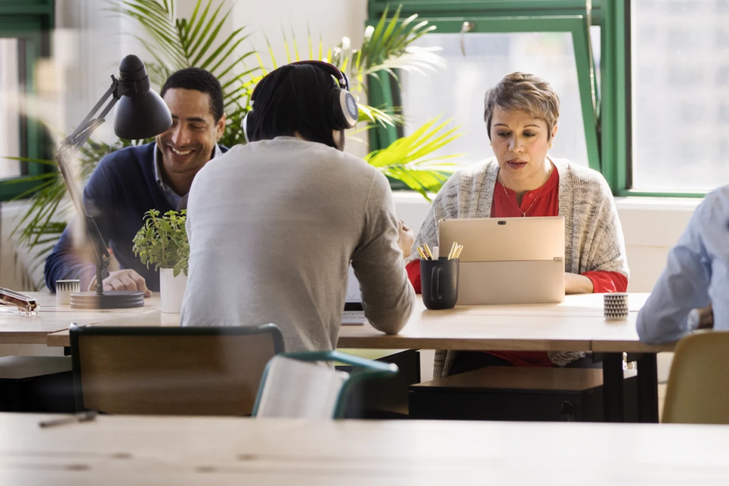 A group of coworkers strategizing how to utilize AI in their workflow.