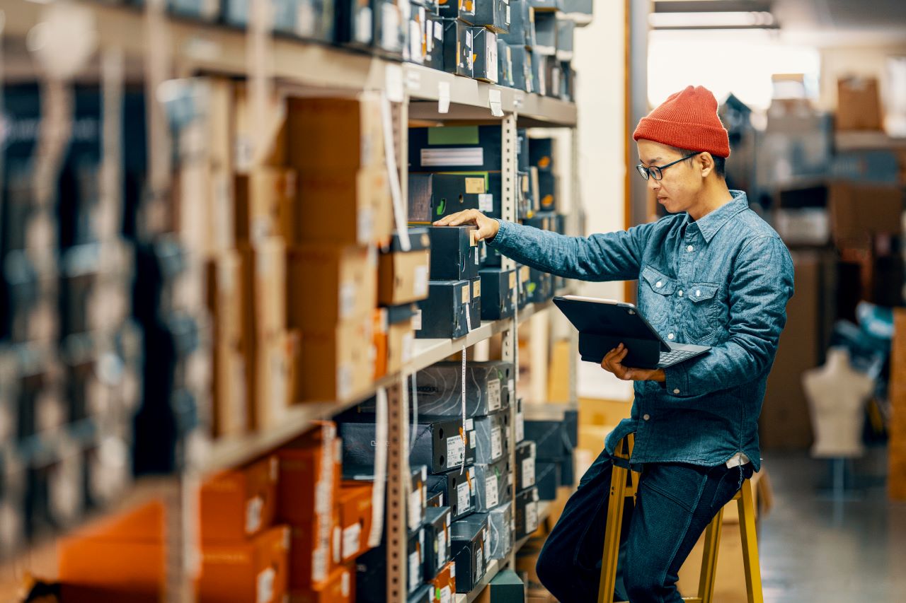 A man on a ladder looking at a tablet