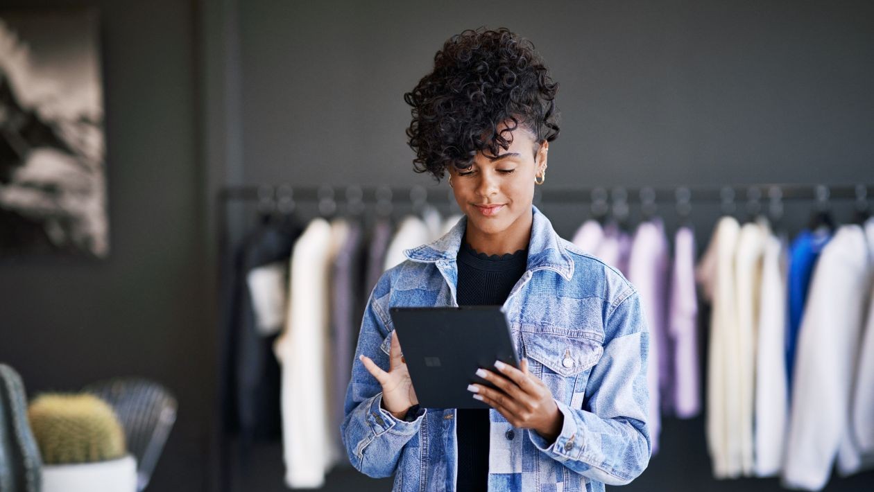 A woman holding a tablet in a retail store.