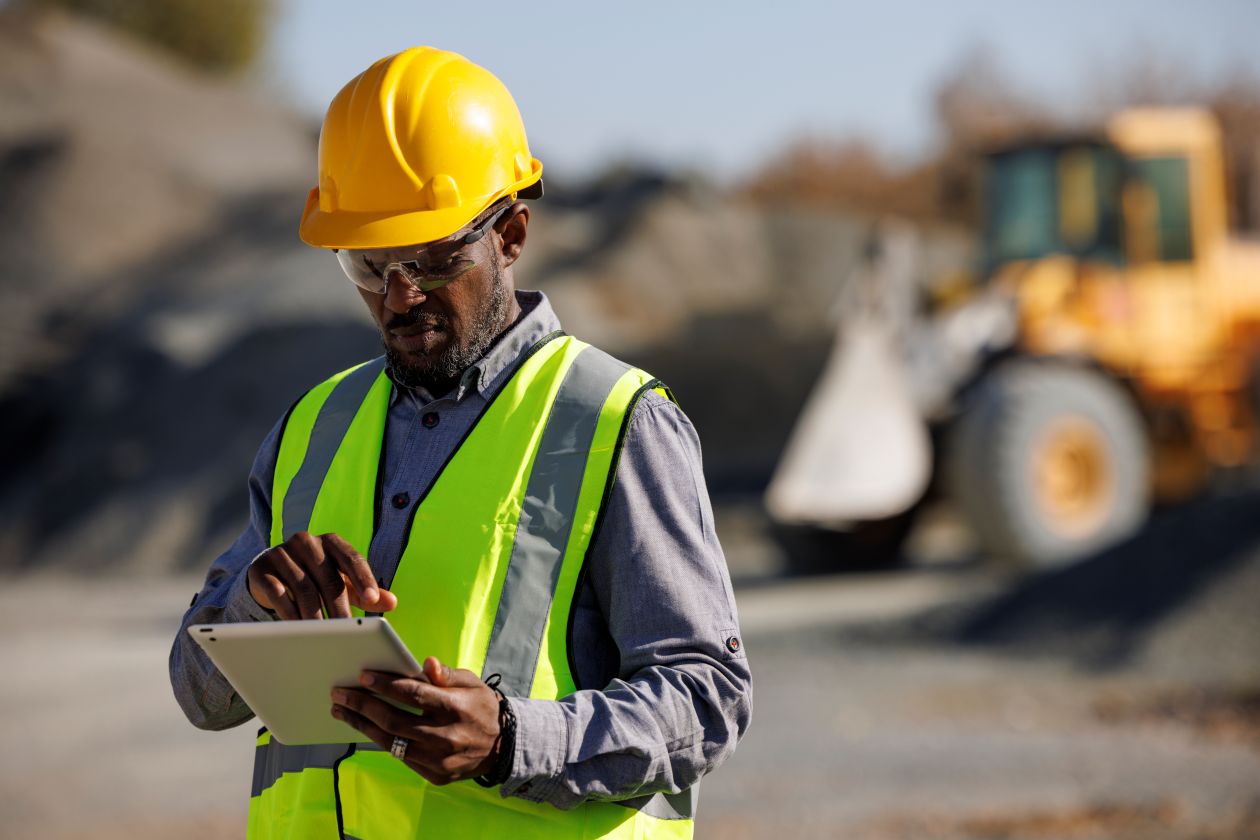 Person working on a tablet on a construction work site.