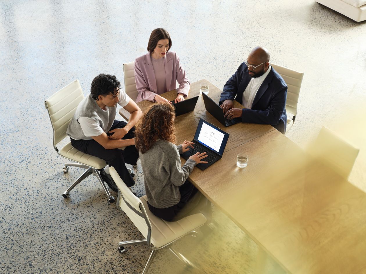 A Lenovo device being used by a mixed-gender team in an office space.