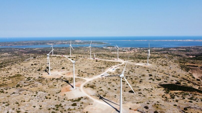 A decorative image of a field with wind turbines