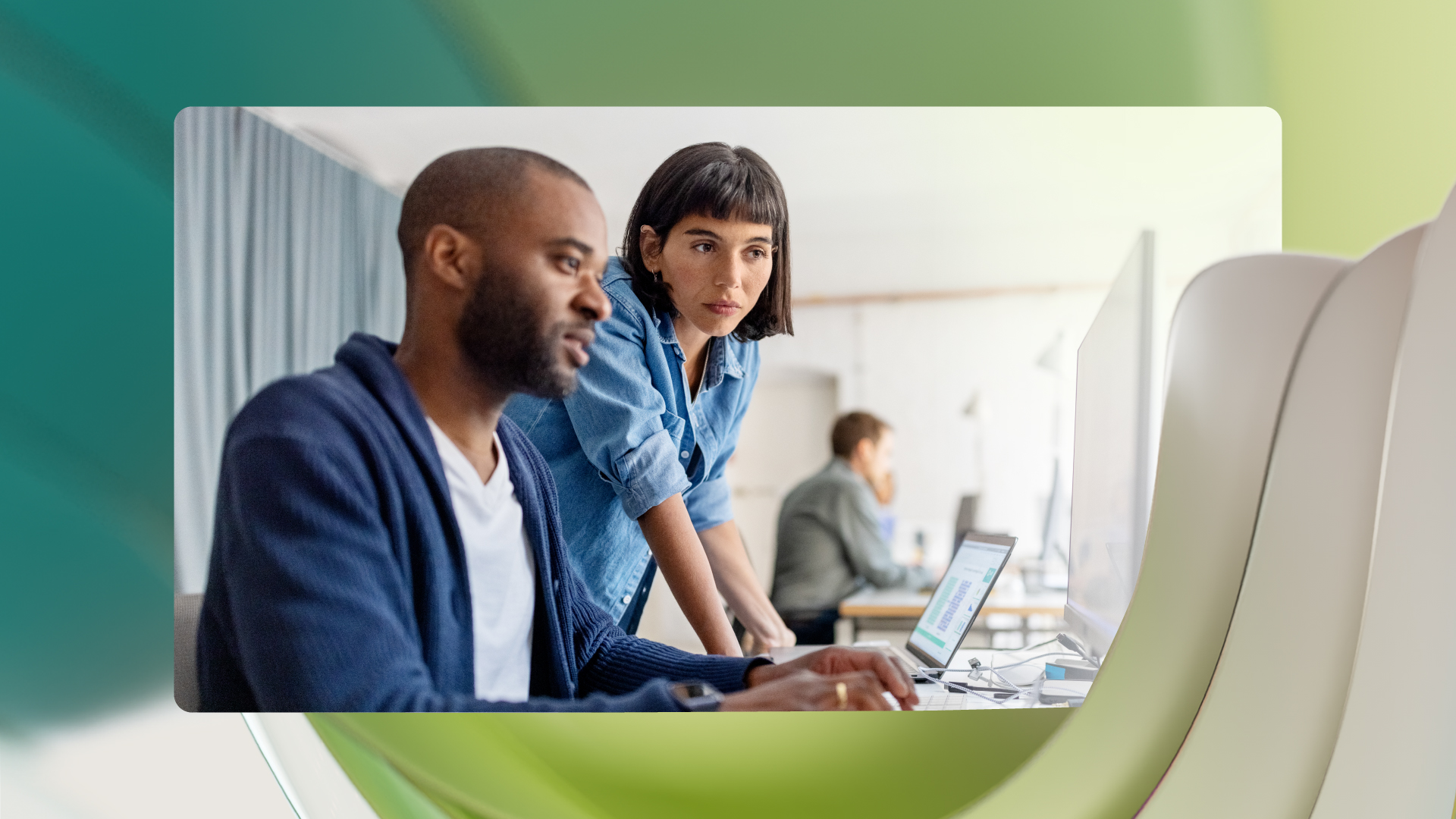 Two coworkers looking at data on a computer.