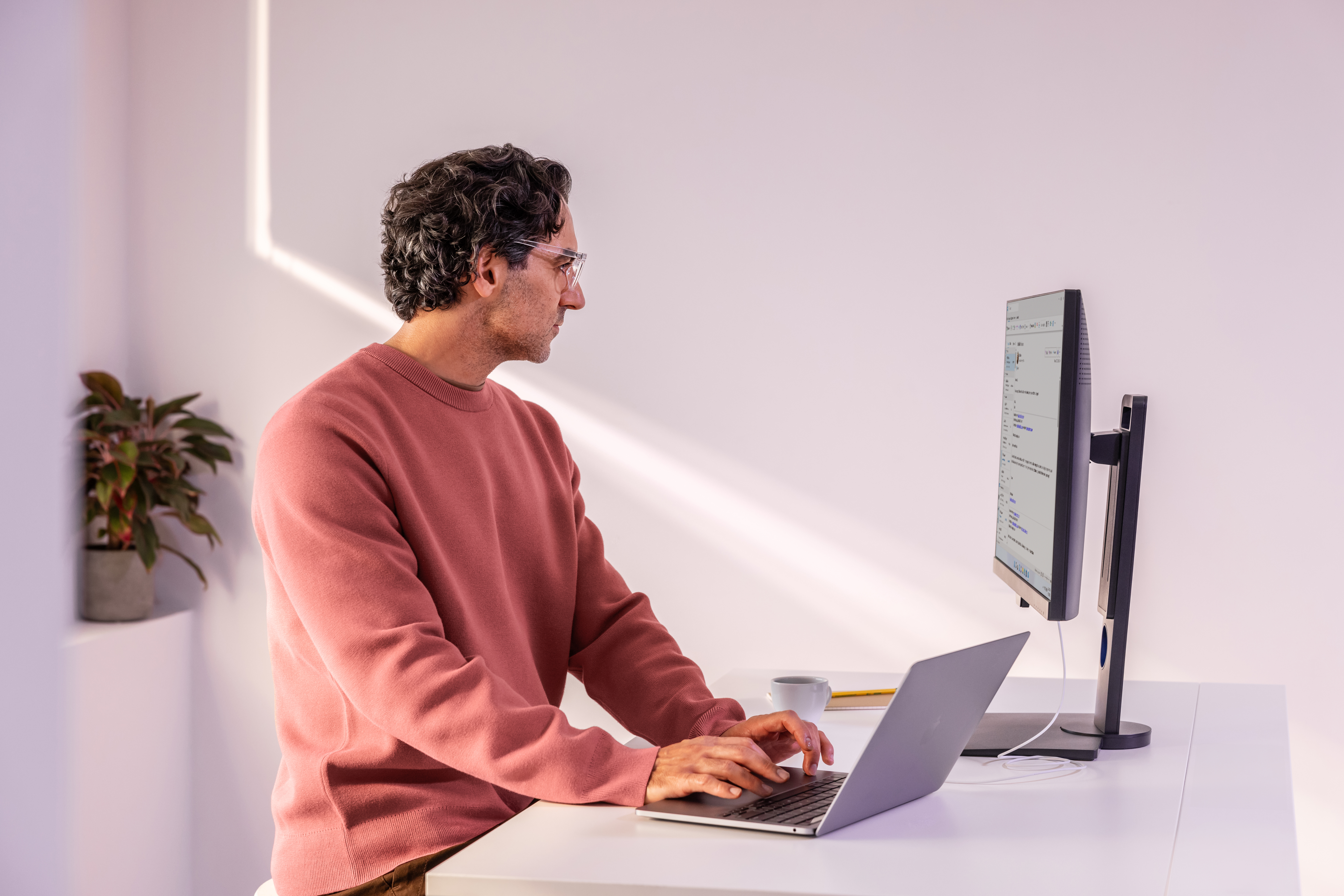 A man sitting at a desk using a laptop