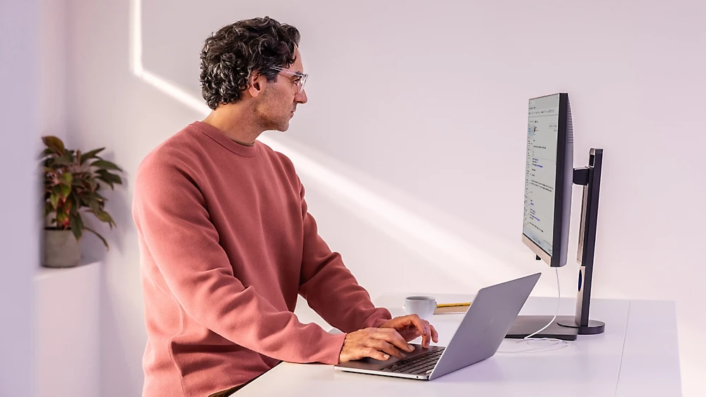 A man sitting at a desk using a laptop