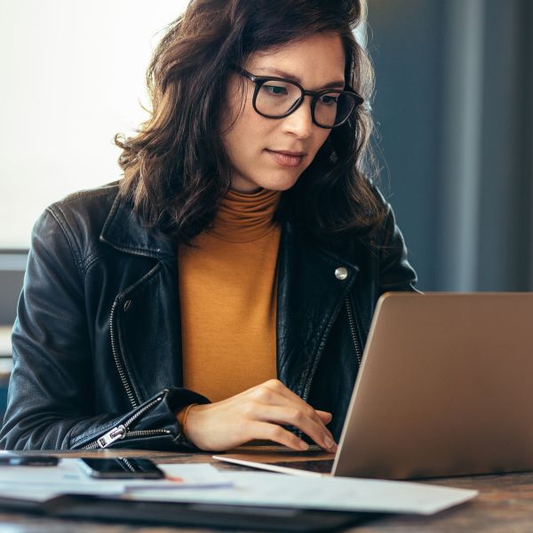 A maker working on a laptop in a common area in a workplace.