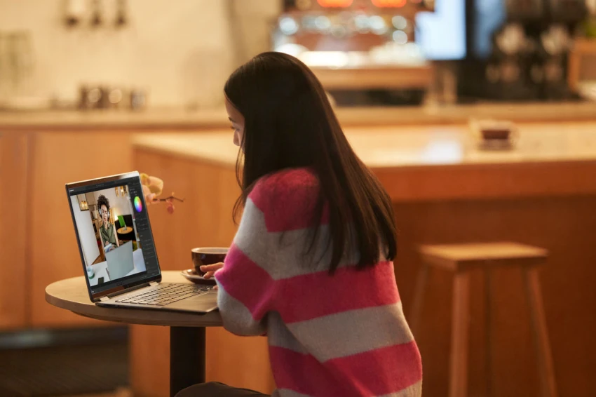 Decorative, a young adult inside working on a laptop using Adobe Lightroom.