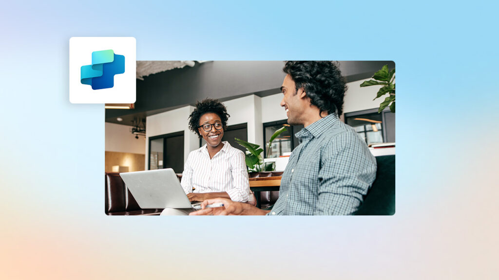 A man and woman sitting at a table with a laptop
