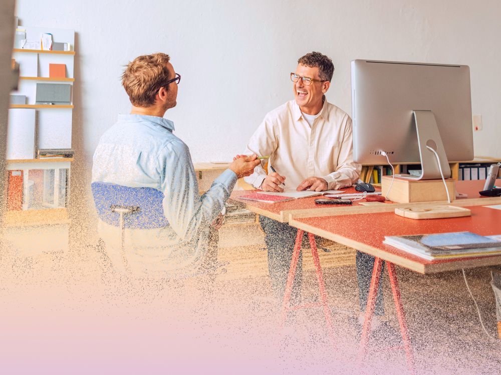 Two men collaborating joyfully at work