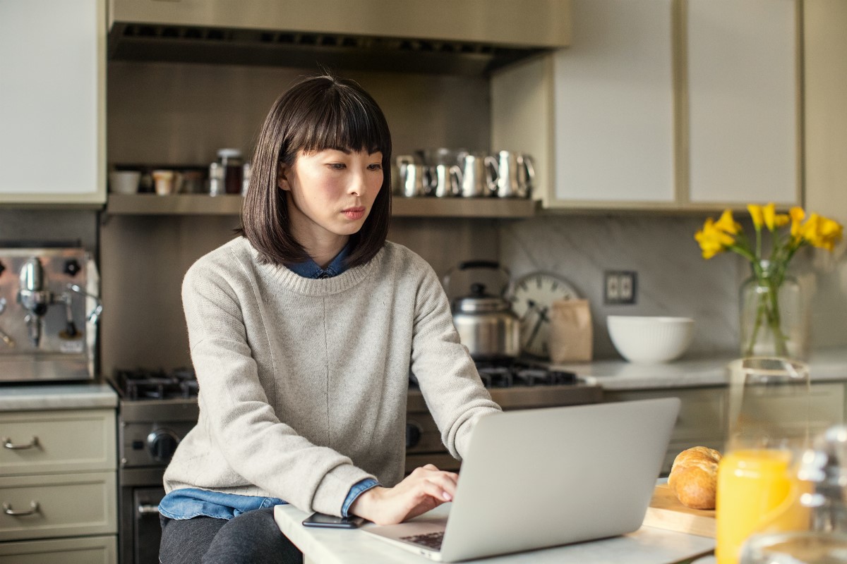 Female working on laptop in kitchen