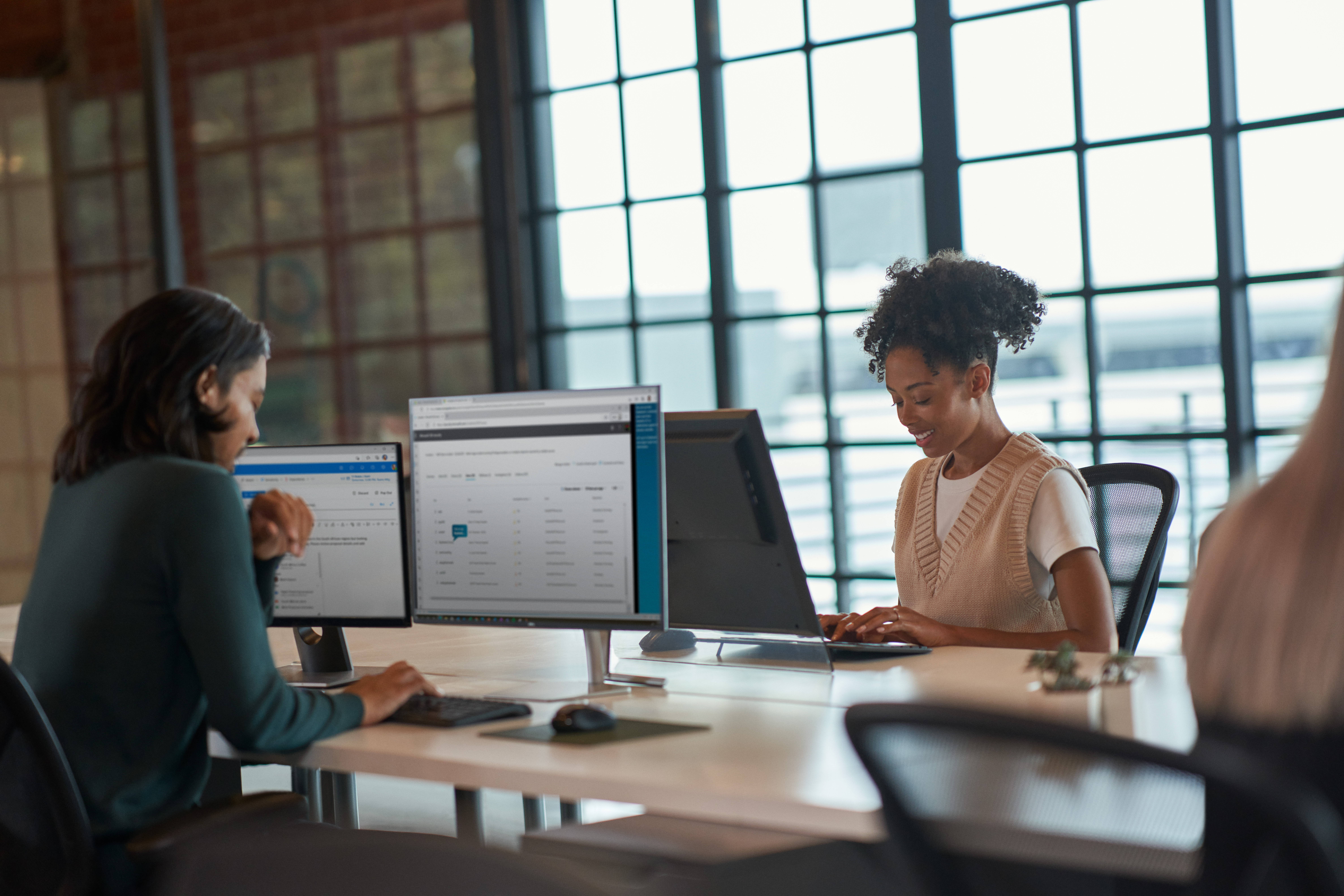 A woman sitting at a desk with a computer