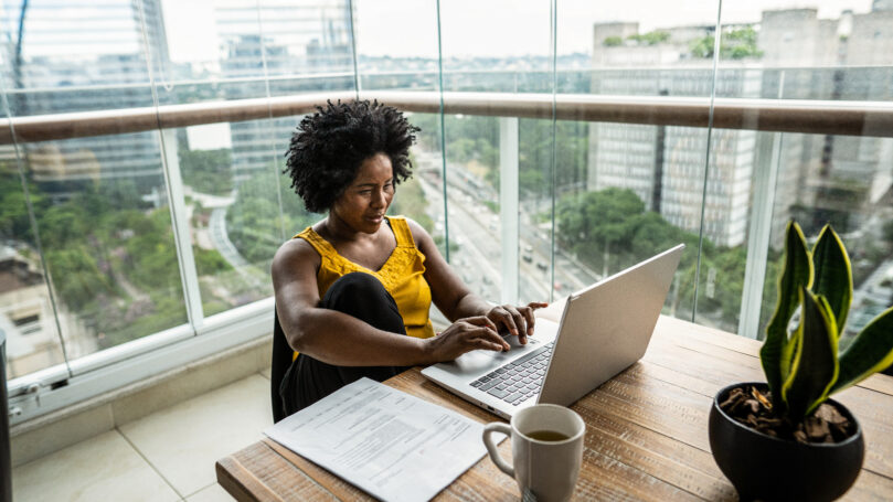 A woman sitting at a table with a laptop