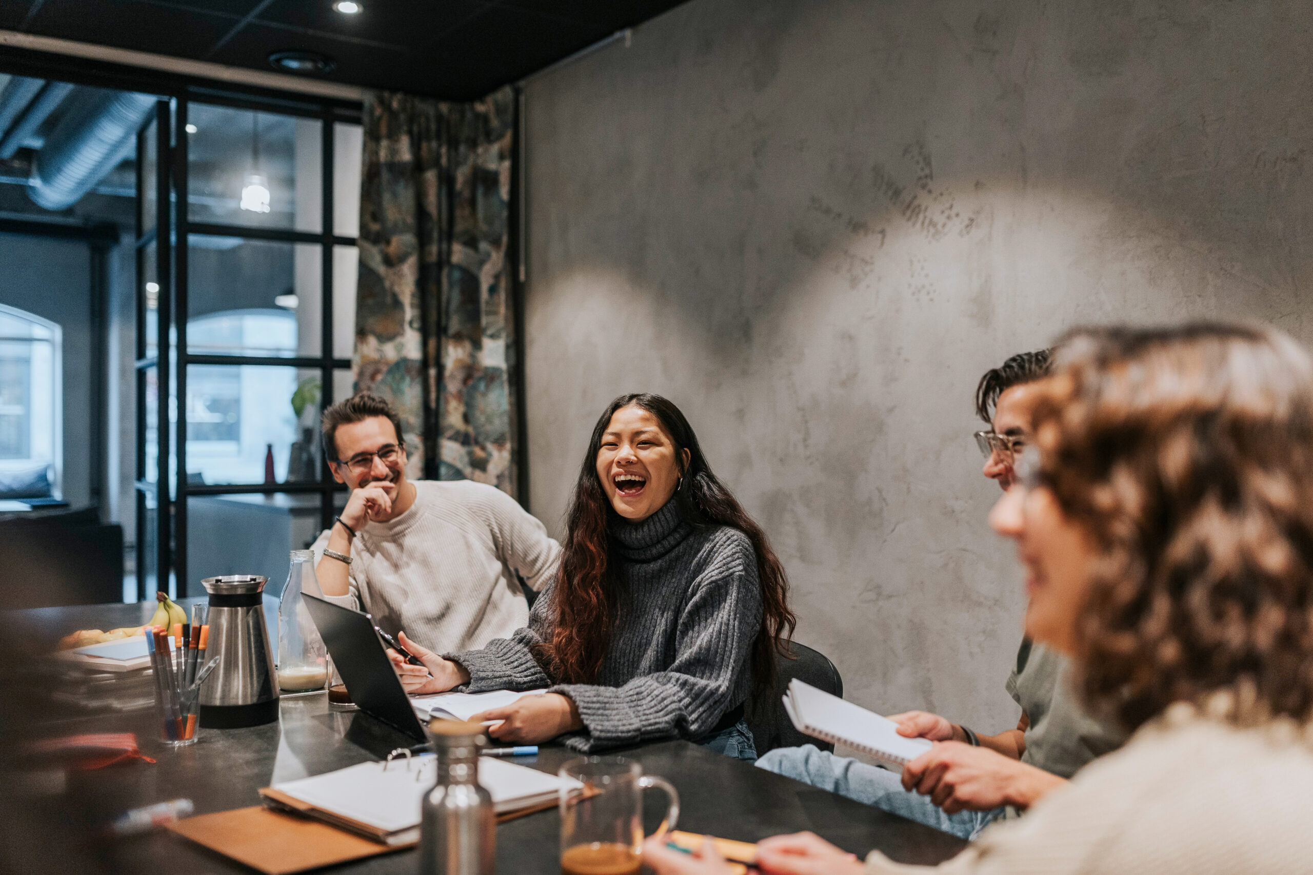 A group of people sitting at a table laughing