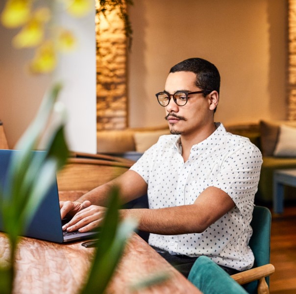 A man sitting at a table using a laptop