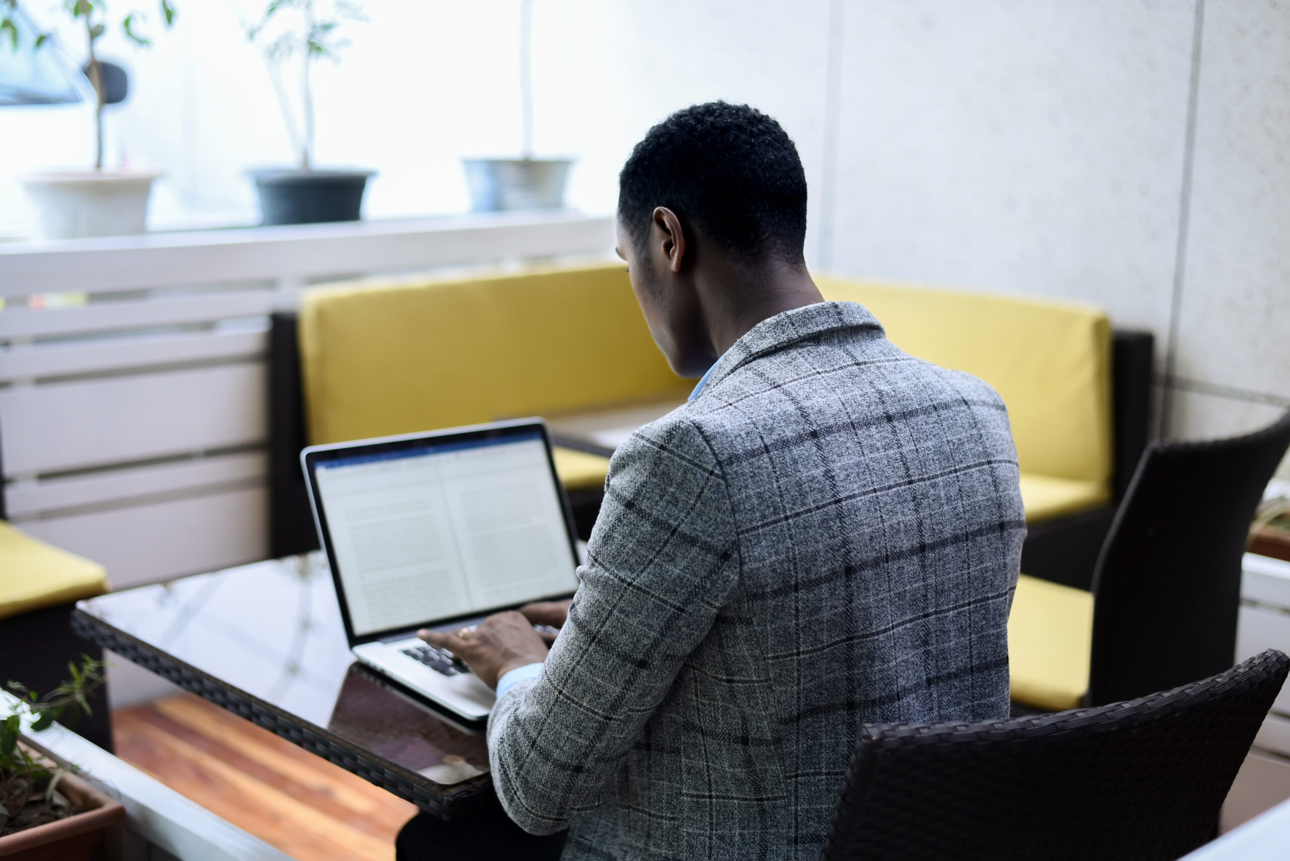 A man sitting at a table using a laptop