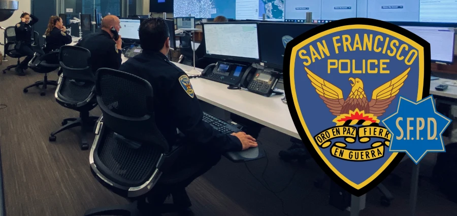 A police officer sitting at a desk in an office. 