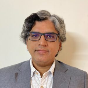 A man wearing glasses and a suit