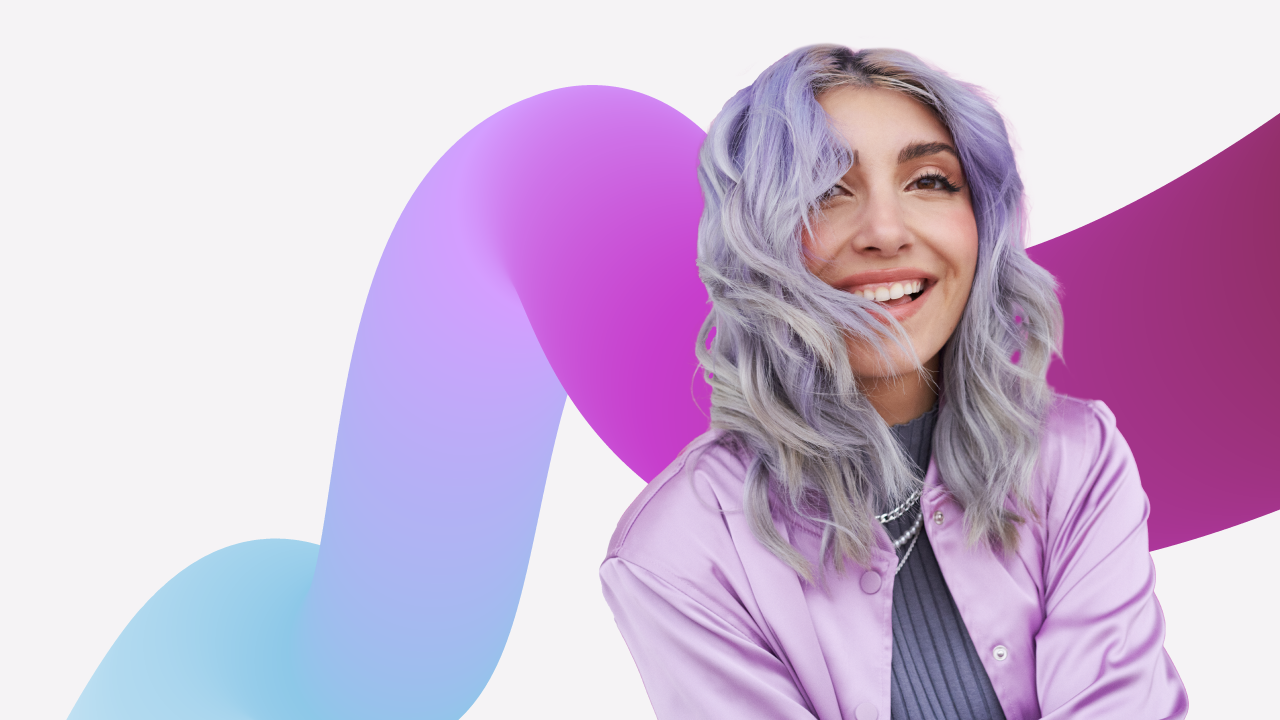 Portrait of a woman smiling with hair in her face in front of a decorative background.