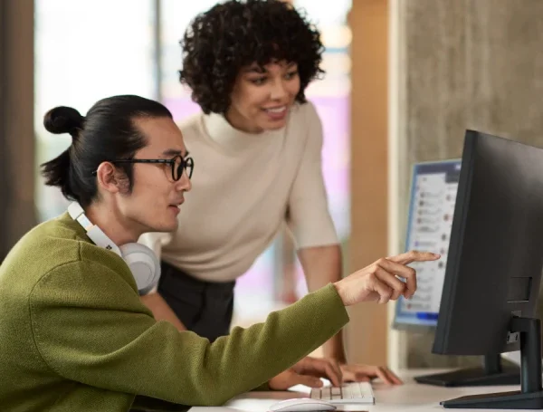 A man and woman looking at a computer screen