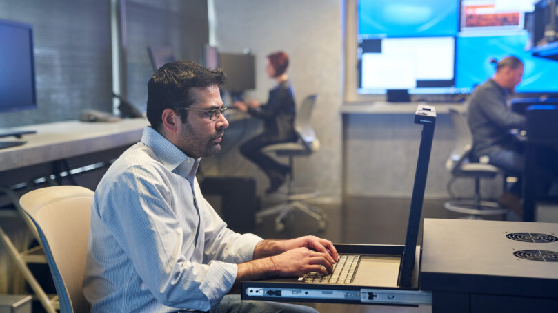 A man sitting at a desk with a laptop