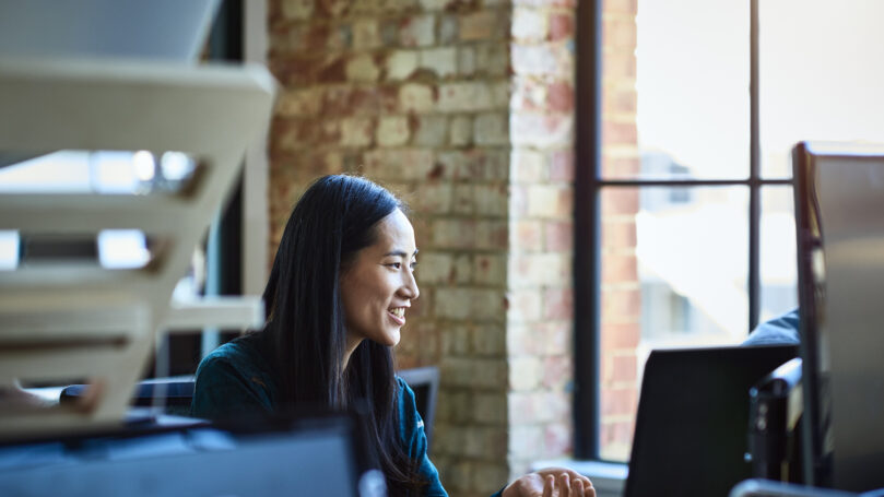 A woman smiling at a computer