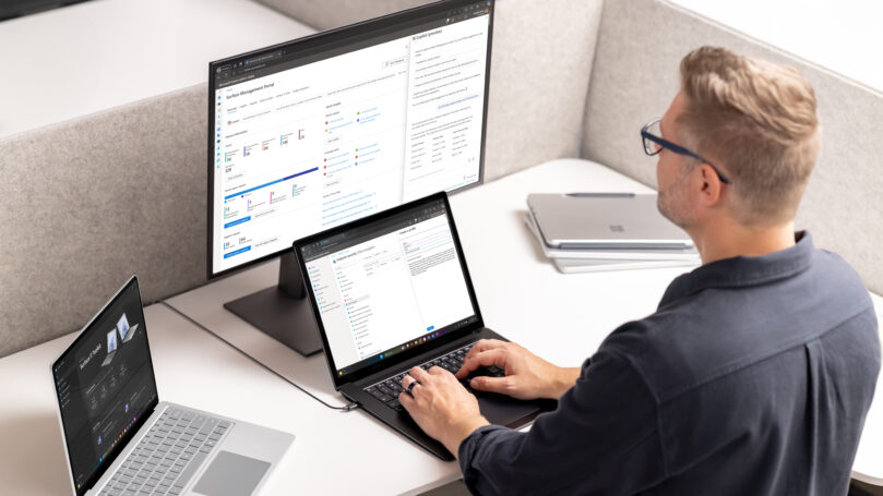 A man sitting at a desk with two computers