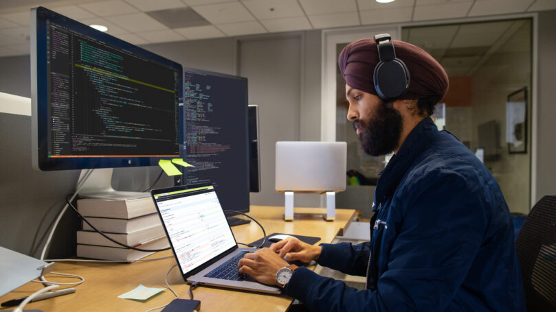 A man wearing headphones and using a laptop