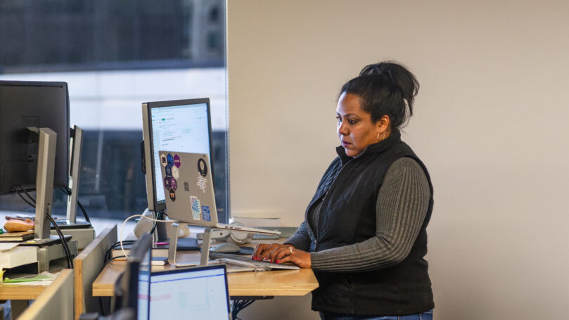 A woman standing in front of a computer