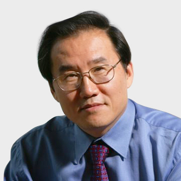 a man wearing a suit and tie smiling at the camera