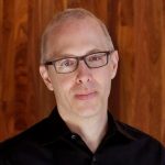 Daniel Goldstein wearing glasses and looking at the camera