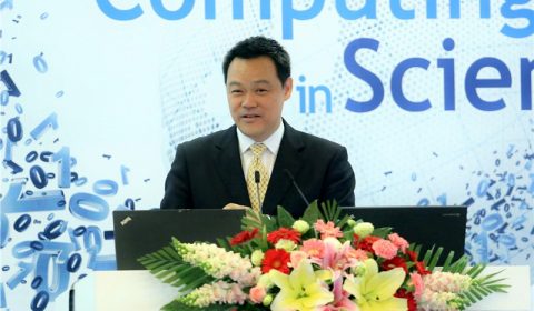 a man in a suit standing in front of a flower
