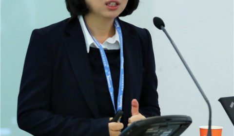 a person in a suit standing in front of a box
