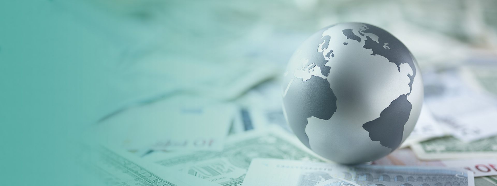 Metal globe resting on paper currency