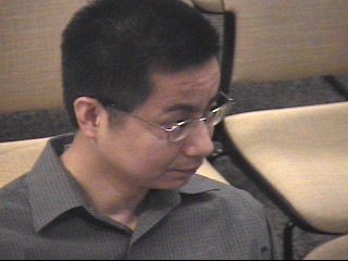 a man in glasses looking at the camera