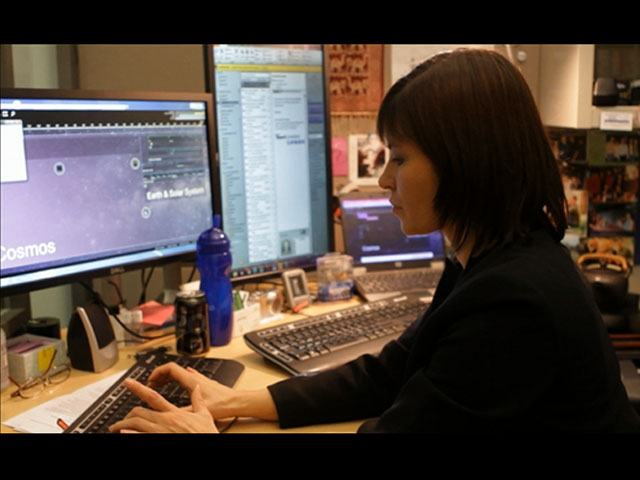 a person sitting at a desk in front of a laptop computer
