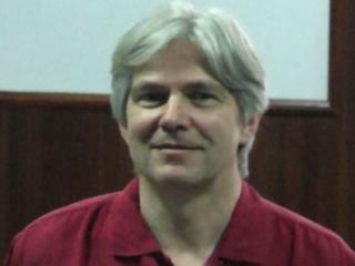 a man wearing glasses and smiling at the camera