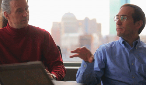 a man sitting in front of a laptop