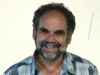 a man wearing glasses and smiling at the camera