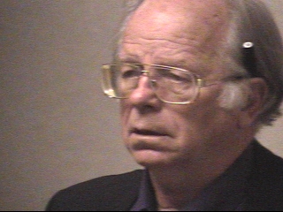 a man wearing glasses and looking at the camera