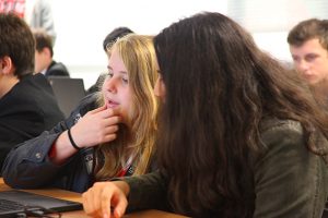 a group of people looking at a laptop