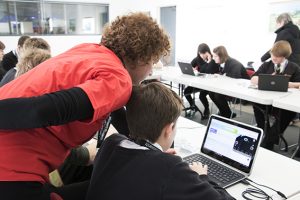 a group of people looking at a laptop